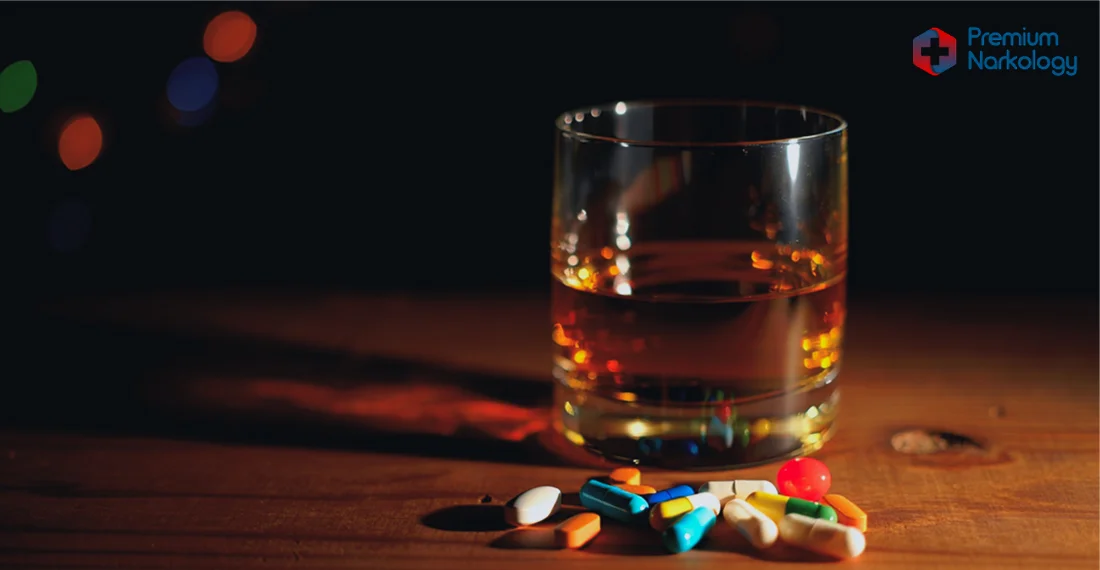 Стакан с алкоголем и таблетки